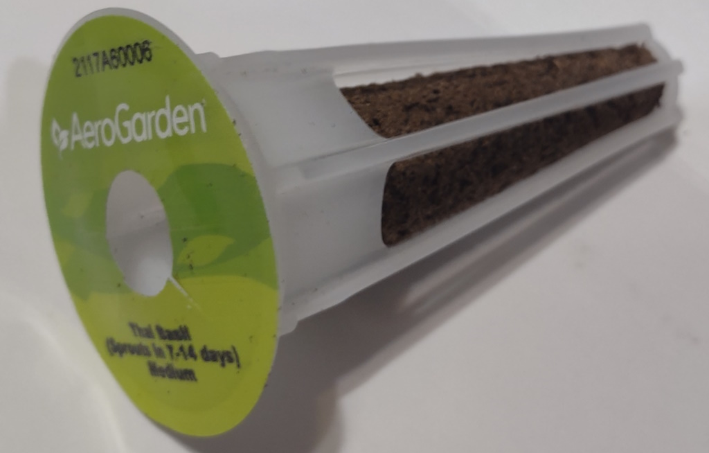 An AeroGarden pod with a sticker on the top and a grow plug inside