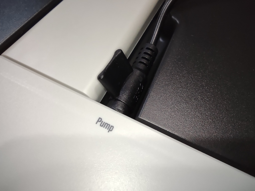 Close-up of the water pump power cable plugged into socket on the AeroGarden Harvest base